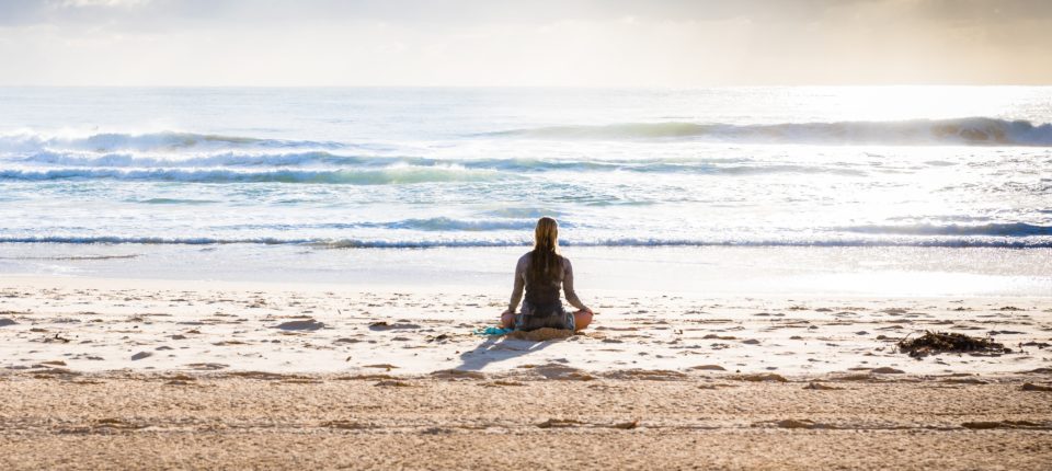 Women meditating near the beach